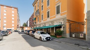 A row of parked cars along a street with a building featuring a green awning and a sign that reads 'Hotel Prati Centenari.' - GuestHost - Comfortable 30m2 studio, perfect for 2, located on the second floor of a building with lift.The apartment is located in the Ca' Granda - Prato Centenaro area, located in Municipality 9 north of Milan, a well-connected residential area (M5 Ca' (Milan)