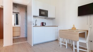 A compact kitchen with white cabinets, a microwave, a coffee maker, and a wooden table. - GuestHost - Comfortable 30m2 studio, perfect for 2, located on the second floor of a building with lift.The apartment is located in the Ca' Granda - Prato Centenaro area, located in Municipality 9 north of Milan, a well-connected residential area (M5 Ca' (Milan)