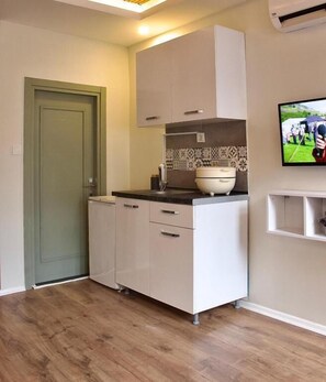 A compact kitchen with white cabinets, a countertop, a sink, and a tiled backsplash. - PeraHomes De (İstanbul)