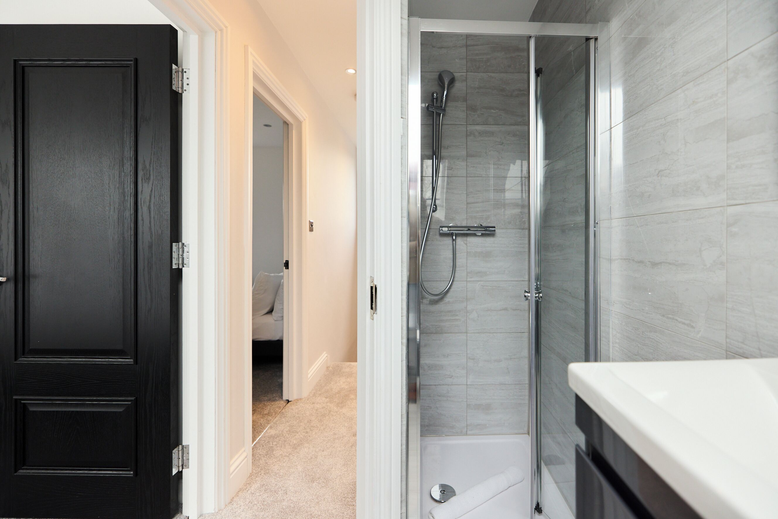 Et moderne badeværelse med bruser, badekar og toilet.