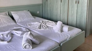 Quarto com cama, guarda-roupa e luminária pendente.