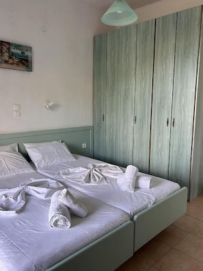 Ein Schlafzimmer mit einem Bett, einem Kleiderschrank und einer Pendelleuchte.