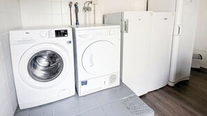 Kompakti pyykinhuoltotila, jossa on etukuormauspesukone, kuivausrumpu ja jääkaappi.