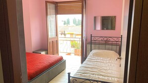 Un dormitorio con dos camas, un balcón y vistas al exterior.
