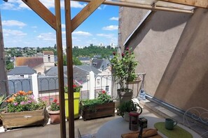 A rooftop terrace with potted plants, a table with chairs, and a view of the cityscape. - Downtown studio apartment with a spacious private terrace—quiet and bright (Poitiers)
