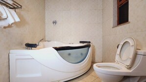 Et badeværelse med badekar, toilet og håndklædestige.