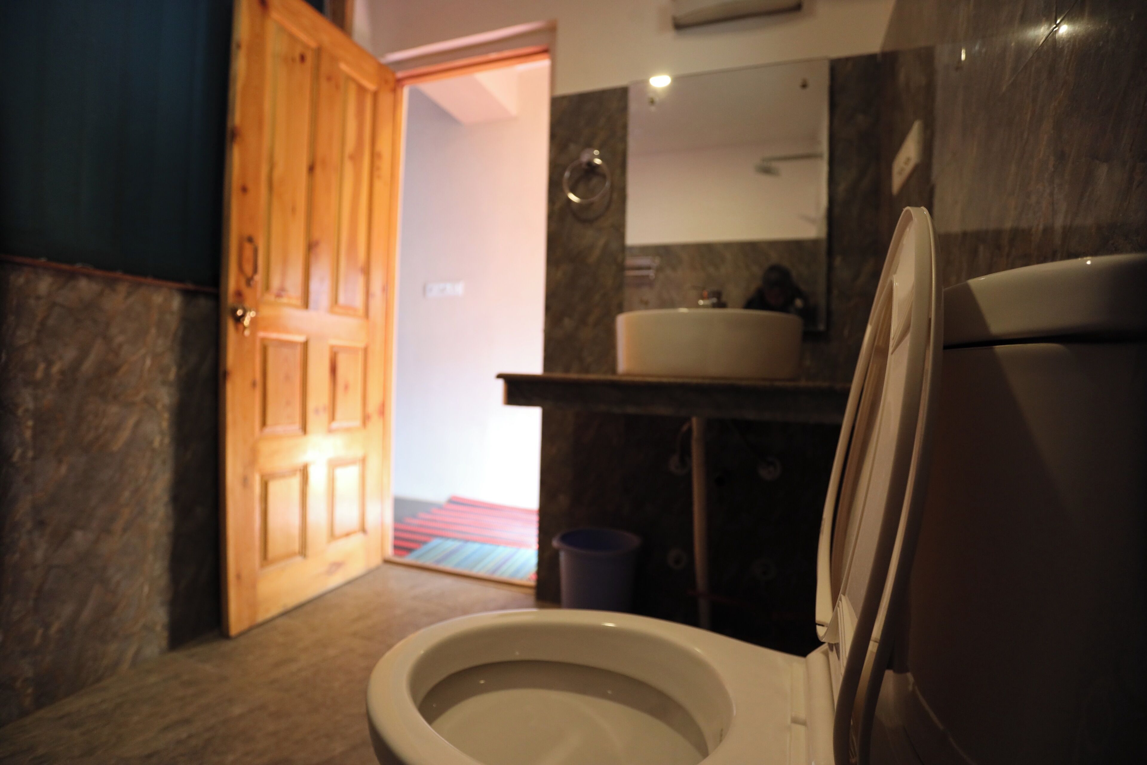 Une salle de bain avec des toilettes, un lavabo et un miroir.