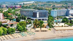 Un hôtel situé sur la côte, composé de plusieurs bâtiments, avec une plage et un espace piscine.