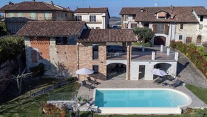 Propiedad residencial con piscina, mobiliario exterior y vistas a casas vecinas.