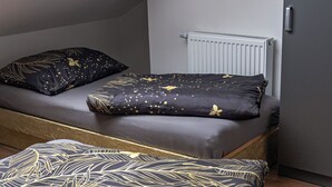 Una stanza compatta con un letto, una finestra e un termosifone.