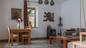 Ein Wohnzimmer mit einem Holzesstisch, Stühlen, einer Couch, einem Kamin und Dekoration an den Wänden.