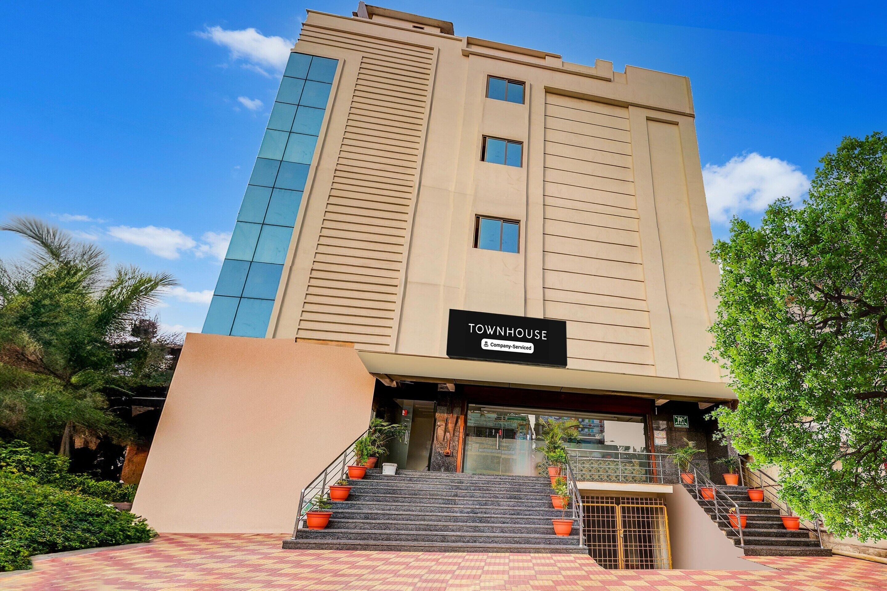 Un edificio de varios pisos con un letrero que dice 'TOWNHOUSE'.