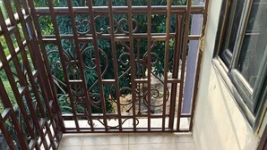 Ein Balkon mit gemusterten Fliesen, einem Metallgitter und einem Fenster.