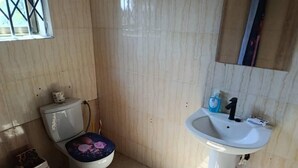 Ein Badezimmer mit Toilette, Waschbecken und einem Fenster.