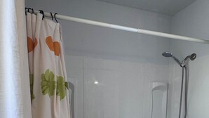 Ein Badezimmer mit Badewanne, Dusche und Vorhang.