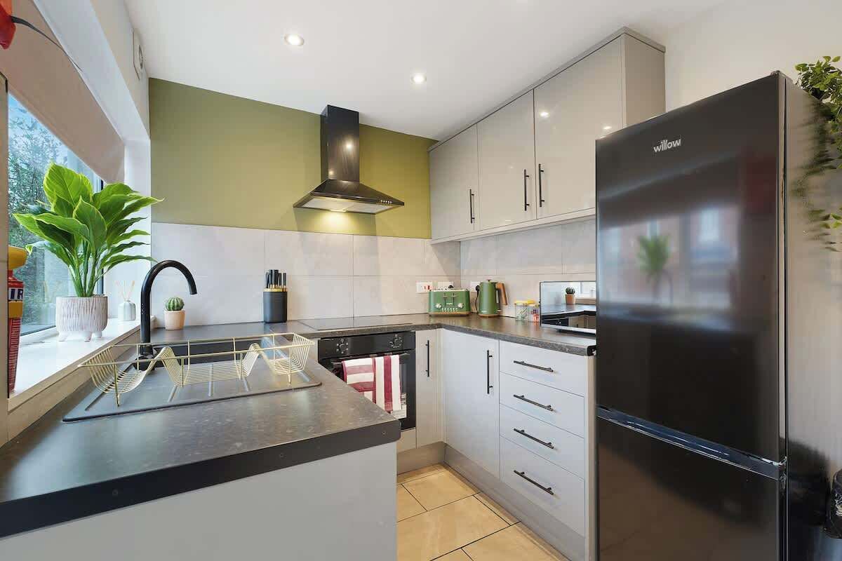 A modern kitchen with a built-in island, stainless steel appliances, and a window with a view.