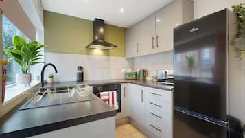 A modern kitchen with a built-in island, stainless steel appliances, and a window with a view.