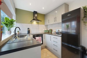 A modern kitchen with a built-in island, stainless steel appliances, and a window with a view.
