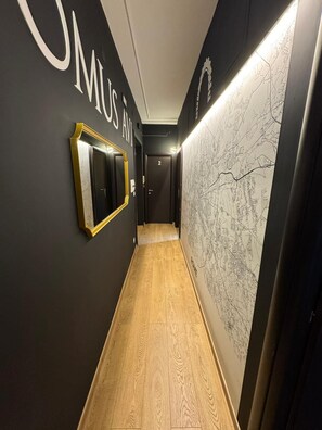 A hallway with a wooden floor, a framed mirror, and a wall with a map. - Domus Avi - Re di Roma (Rome)