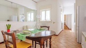 Ein Essbereich mit einem Holztisch, Stühlen und einer grünen Tischdecke.