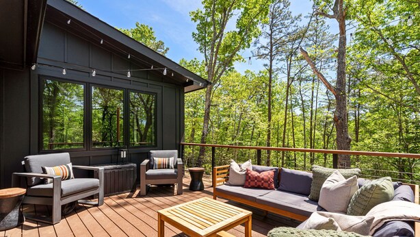 A deck with outdoor furniture, a table, and a sofa with cushions. - Secluded Cabin with King Bed and Fire Pit on 48 Private Acres (Carroll County)