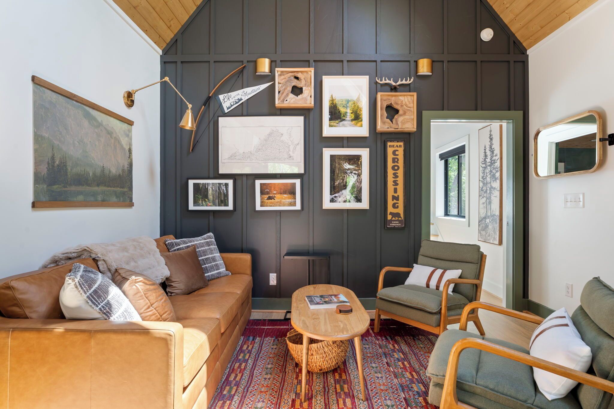 A cozy room with a brown leather sofa, a green armchair, a small wooden table, and a patterned rug.