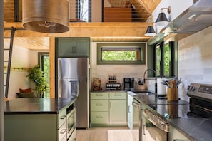 A modern kitchen with a stainless steel refrigerator, a coffee maker, and a window. - Secluded Cabin with King Bed and Fire Pit on 48 Private Acres (Carroll County)