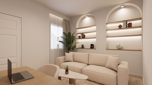 Un salon moderne avec un canapé, une table basse, un ordinateur portable posé sur un bureau et des étagères ornées d’objets décoratifs.