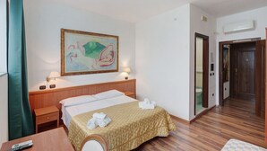 A hotel room with a bed, bedside tables, a painting, a lamp, and a wooden floor. - H Pompeii Ruiins Apartment Hotel - Standard Double Room 5 (Pompei)
