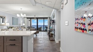 Een moderne keuken met een centraal eiland, een eethoek met uitzicht en een kleurrijke muurschildering.