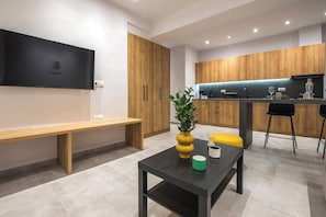 A modern kitchen with wooden cabinets, a black countertop, and a bench. - Athens Urban Diamond Apartment 2 (Athina)