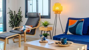Una sala de estar moderna con un sofá, un sillón, una mesa de centro y una lámpara de pie.