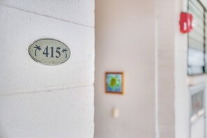 A white wall with a number plate labeled '415' and a small framed picture. - Maui Parkshore #415 Ocean View in the Heart of Kihei, Walk to Kamaole Beach (Kihei)