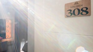 Un letrero de madera con el número 308 y el texto 'ПАНЕАЛЛИОН' en una pared.