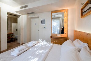 A hotel room with a bed, a mirror with lights, a wooden headboard, and a door leading to a bathroom. - Panellinion Beachfront Getaway Balcony w Seaview (Kalamata)