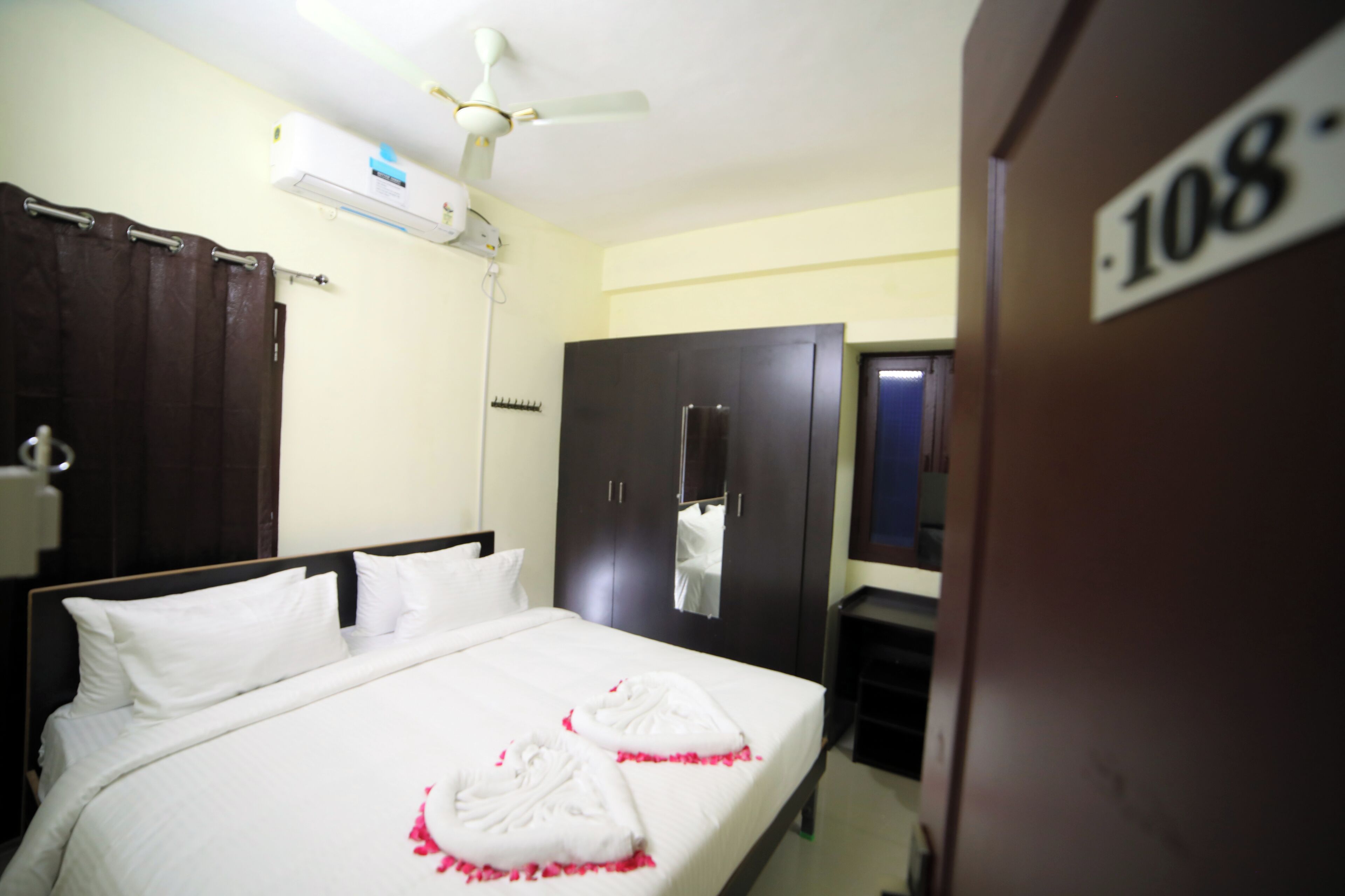 Une chambre d’hôtel équipée d’un lit, d’une armoire, d’un ventilateur de plafond et d’un appareil de climatisation.