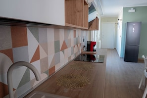 A kitchen with a geometric backsplash, a coffee machine, and a refrigerator. - Sea View Apartment with Terrace Lido San Giovanni Gallipoli (Gallipoli)