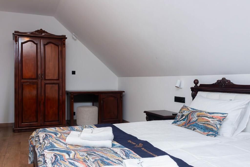 Un dormitorio con cama, armario, mesita de noche y lámpara.