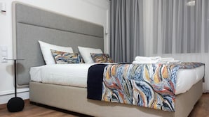 A bed with a grey headboard, white bedding, and a colorful blanket. - Lipowa32 Apartamenty (Hrubieszów)