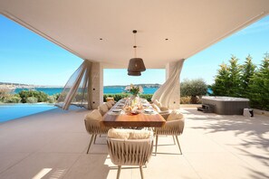 An outdoor dining area with a view of the sea, a hot tub, and a pool. - Luxury Beachfront Villa Malia Trogir with Pool (SegetDonji)