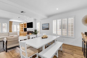 A modern living room with a white dining table, white chairs, a sofa, and a TV. - Luxury & Location! Always Summer!  New! (Newport Beach)