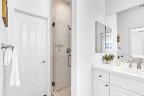 A modern bathroom with a shower, a sink with a mirror, and a towel rack. - Luxury & Location! Always Summer!  New! (Newport Beach)