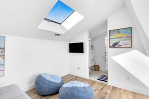 A modern room with a skylight, a flat-screen TV, and a painting. - Luxury & Location! Always Summer!  New! (Newport Beach)