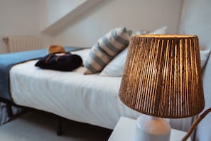 A bedroom with a bed, a lamp, and a pillow. - Casa 'La Marisol Ribeira' with Sea Views, Private Terrace and Wi-Fi (A Coruña)