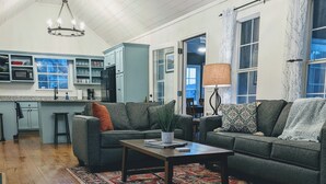 Ein Wohnzimmer mit einer Couch, einem Couchtisch, einem Teppich und einer Fußmatte.