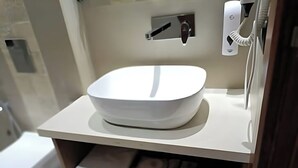 Een badkamer met een witte wastafel, een handdoekhouder en een toilet.