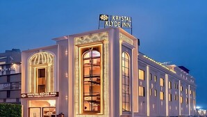 Een hotel met een opvallend bord, grote ramen en een moderne gevel.