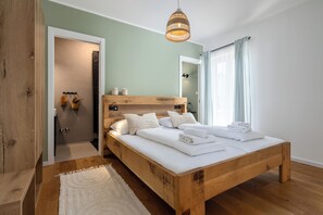 A bedroom with a wooden bed, a hanging light fixture, and a view of the outside through a window. - *NEW* Exclusive, charming country home in Dalmatia. Perfect for friends and family! (Umljanovići)