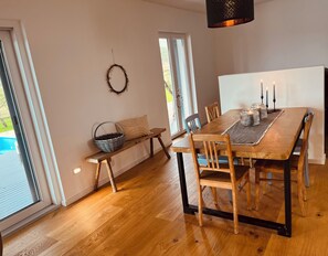 A dining area with a wooden table, chairs, a bench, a basket, a cushion, a wreath, and a hanging light fixture. - *NEW* Exclusive, charming country home in Dalmatia. Perfect for friends and family! (Umljanovići)