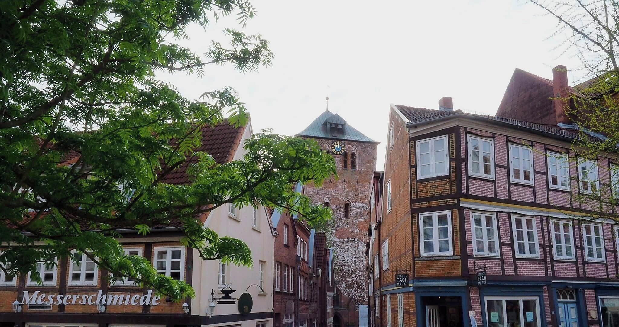 A historic building with a clock tower, traditional European architecture, and a sign for 'Stader Fach Markt'.